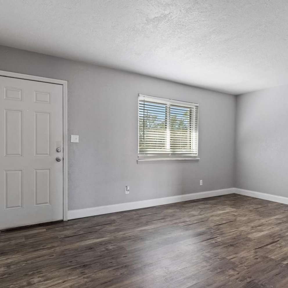 A room with a white door and a window with blinds.